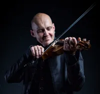 Spelman med fiol framifrån beskärd i höjd med bröstet